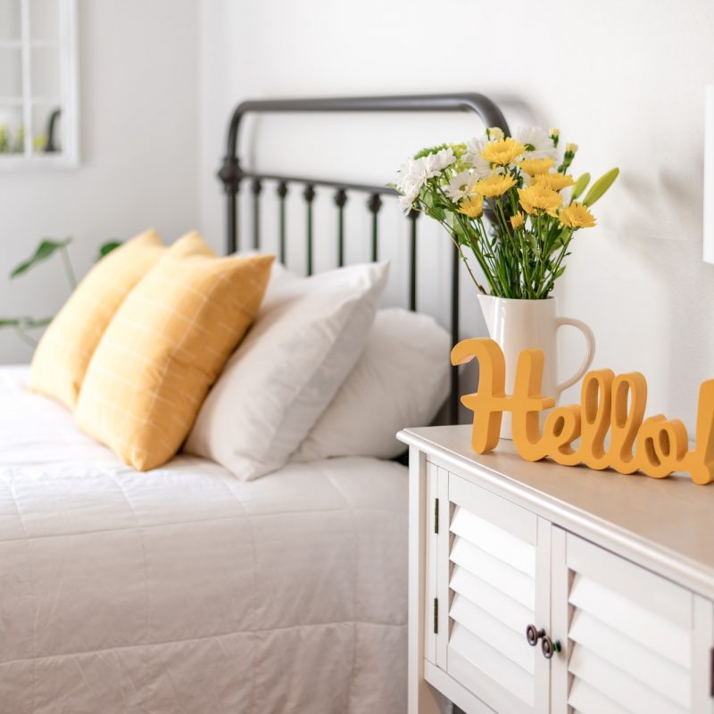 cheerful-hello-sign-and-fresh-flowers-in-a-clean-and-bright-bedroom.jpg